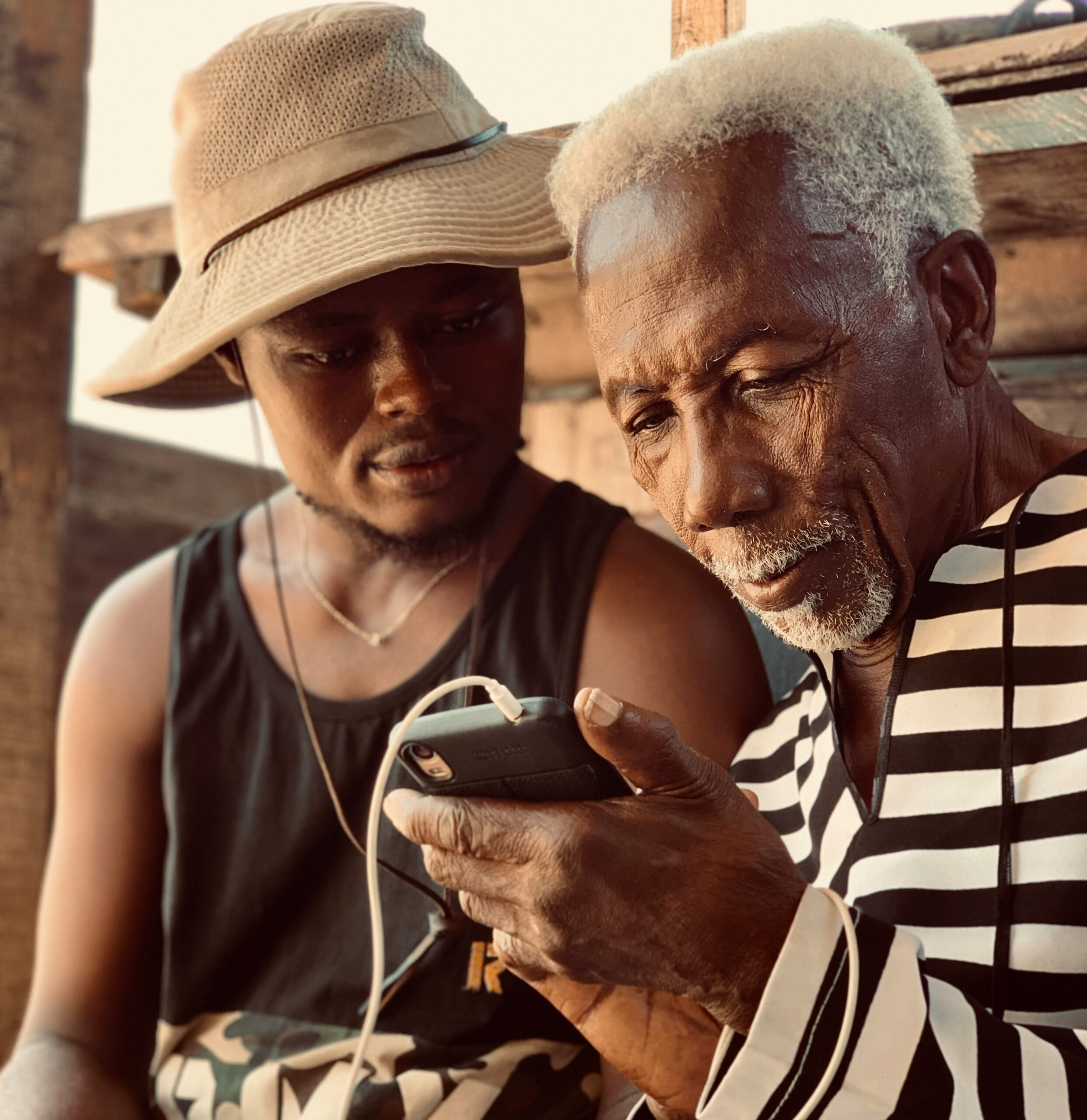 Guy showing younget gut something on cell phone